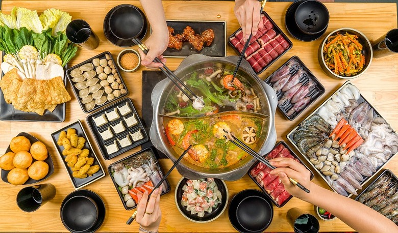 Bốn kiểu nồi lẩu Thái đặt cạnh nhau — Tom Yum đỏ, Suki trong, Mookata nướng, Shabu thanh