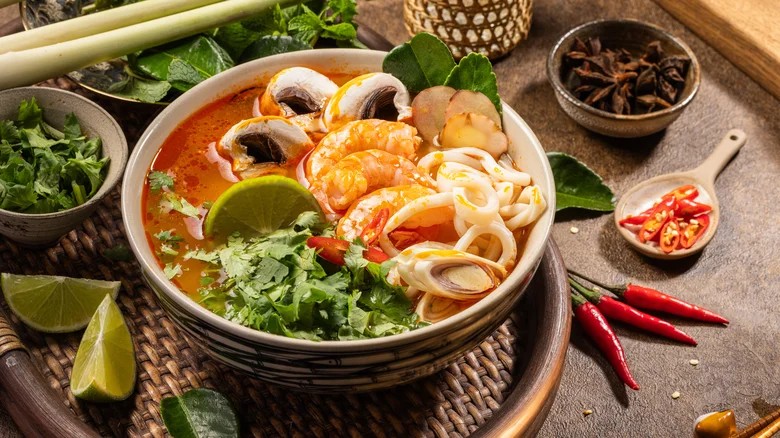 Ba tô tom yum phiên bản khác nhau — goong, gai, talay — đặt trên bàn đá cẩm thạch trong nhà hàng Bangkok