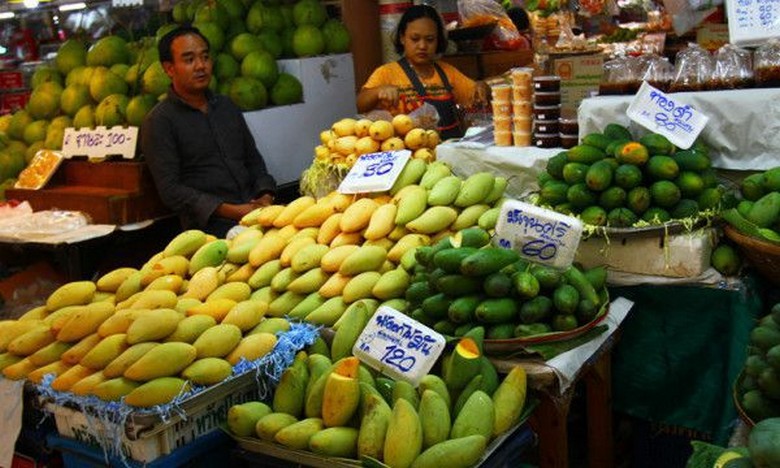 Góc chợ Or Tor Kor Market buổi sáng sớm với các quầy trái cây nhiệt đới và ẩm thực Thái truyền thống